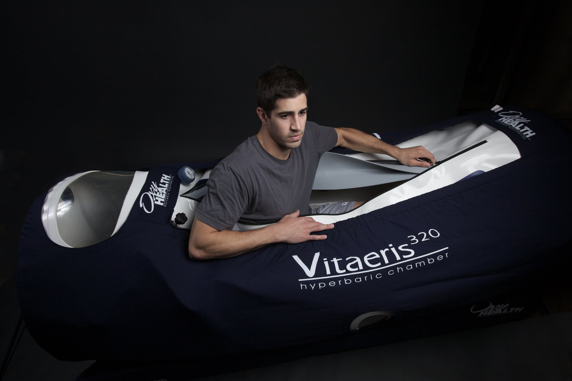 Person interacting with a large inflatable chamber labeled 'Vitaeris 320' on a dark background