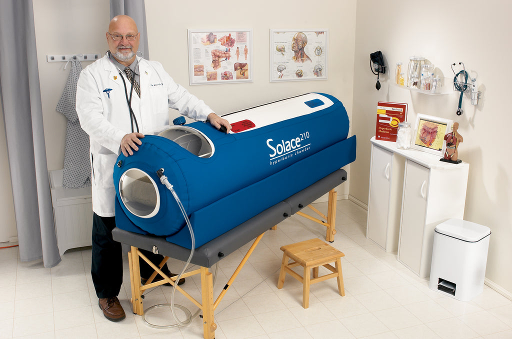 Doctor standing next to a Solace 10S hyperbaric chamber in a clinical setting.