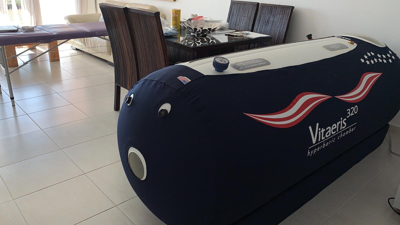 Inflatable hyperbaric chamber with 'Vitaeris 320' branding in a room setting.